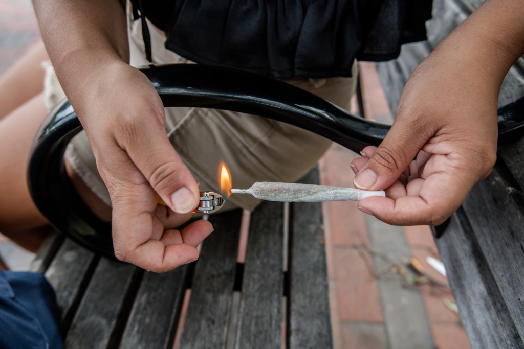 a photo of a person ligthing a pre-roll to illustrate branding a cannabis business